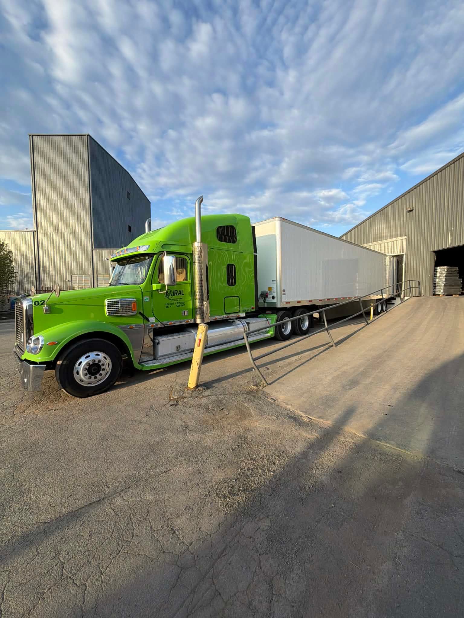 Miral's lime green Freightliner Coronado backed into a loading dock